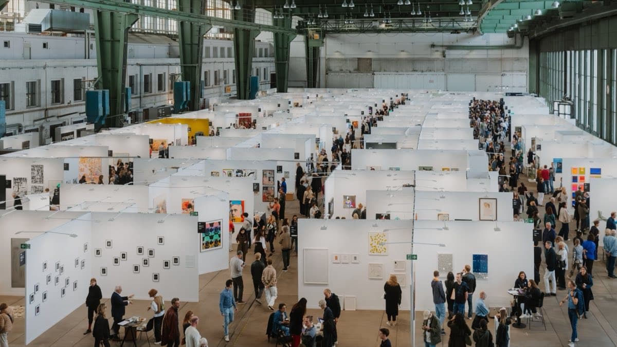 Visitors browsing gallery booths at POSITIONS Berlin Art Fair in Tempelhof's Hangar 5
