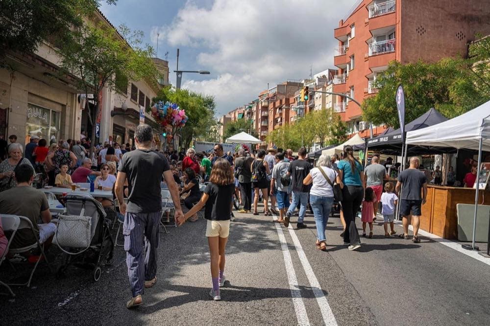 Crowds walking a decorated street during a Barcelona neighbourhood festa
